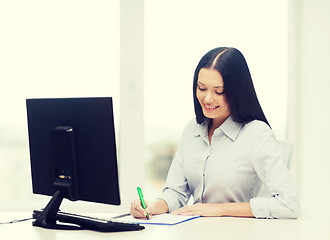 Image showing smiling businesswoman or student studying