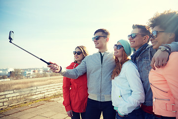 Image showing smiling friends taking selfie with smartphone