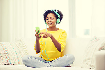 Image showing happy african woman with smartphone and headphones