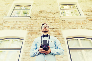 Image showing happy young hipster man with film camera in city