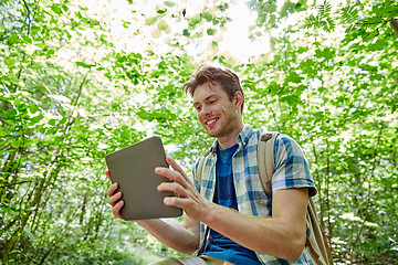 Image showing happy man with backpack and tablet pc in woods