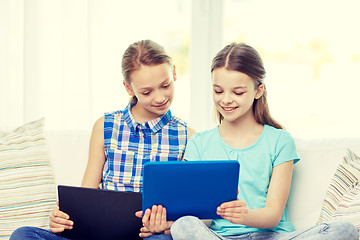 Image showing happy girls with tablet pc sitting on sofa at home