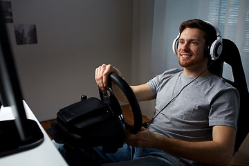 Image showing man playing car racing video game at home