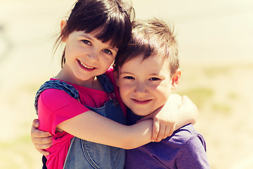 Image showing two happy kids hugging outdoors