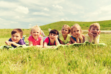 Image showing group of kids lying on blanket or cover outdoors