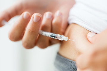 Image showing woman with syringe making insulin injection