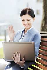 Image showing smiling business woman with laptop in city