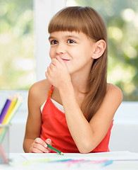 Image showing Little girl is drawing using pencils