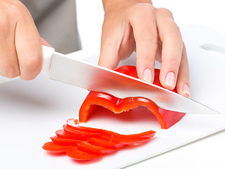 Image showing Cook is chopping bell pepper