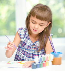 Image showing Little girl is painting with gouache