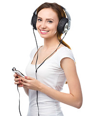 Image showing Young woman enjoying music using headphones