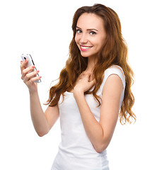 Image showing Young woman is pleased by incoming message