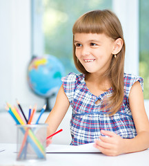 Image showing Little girl is drawing using pencils