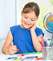 Image showing Little girl is drawing using pencils