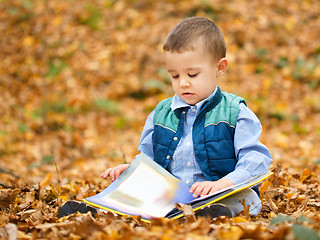 Image showing Little boy is reading book