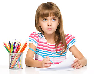 Image showing Little girl is drawing using pencils