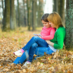 Image showing Mother is reading from tablet with her daughter