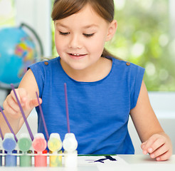 Image showing Little girl is painting with gouache