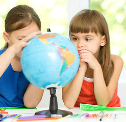 Image showing Little girls are examining globe