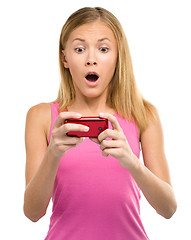 Image showing Young teen girl is reading sms message