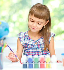 Image showing Little girl is painting with gouache