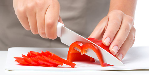 Image showing Cook is chopping bell pepper