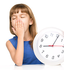 Image showing Little girl is holding big clock