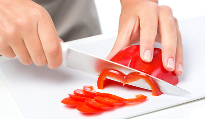 Image showing Cook is chopping bell pepper