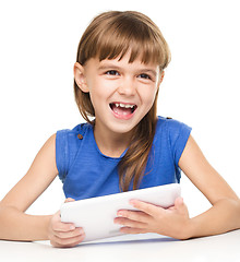 Image showing Young cheerful girl is using tablet