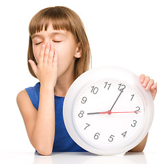 Image showing Little girl is holding big clock