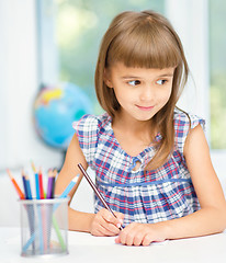 Image showing Little girl is drawing using pencils