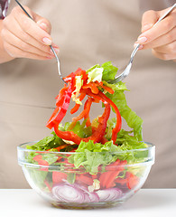 Image showing Cook is mixing salad