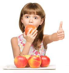 Image showing Little girl with apples is showing thumb up sign