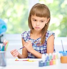 Image showing Little girl is painting with gouache