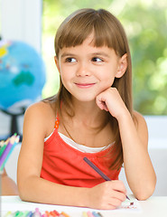 Image showing Little girl is drawing using pencils