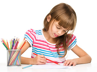 Image showing Little girl is drawing using pencils