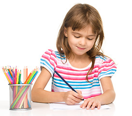 Image showing Little girl is drawing using pencils