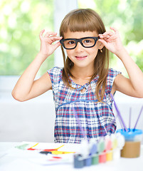 Image showing Little girl is painting with gouache