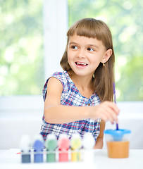 Image showing Little girl is painting with gouache