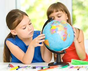 Image showing Little girls are examining globe