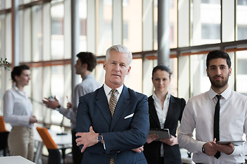 Image showing portrait of senior businessman as leader  with group of people i