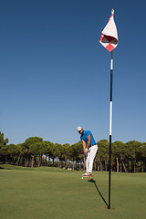 Image showing golf player hitting shot at sunny day