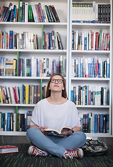 Image showing famale student reading book in library