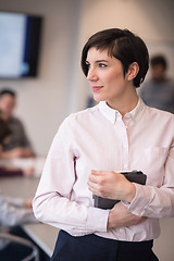 Image showing hispanic businesswoman with tablet at meeting room