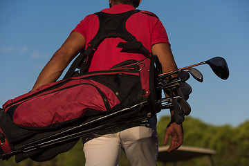 Image showing close up of golfers back while   walking and carrying golf  bag