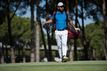 Image showing golf player walking and carrying bag