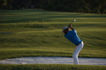 Image showing golfer hitting a sand bunker shot on sunset