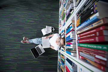 Image showing female student study in library, using tablet and searching for 