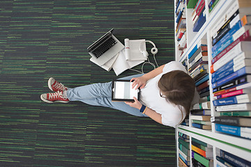 Image showing female student study in library, using tablet and searching for 