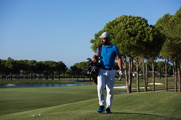 Image showing golfer  walking and carrying bag